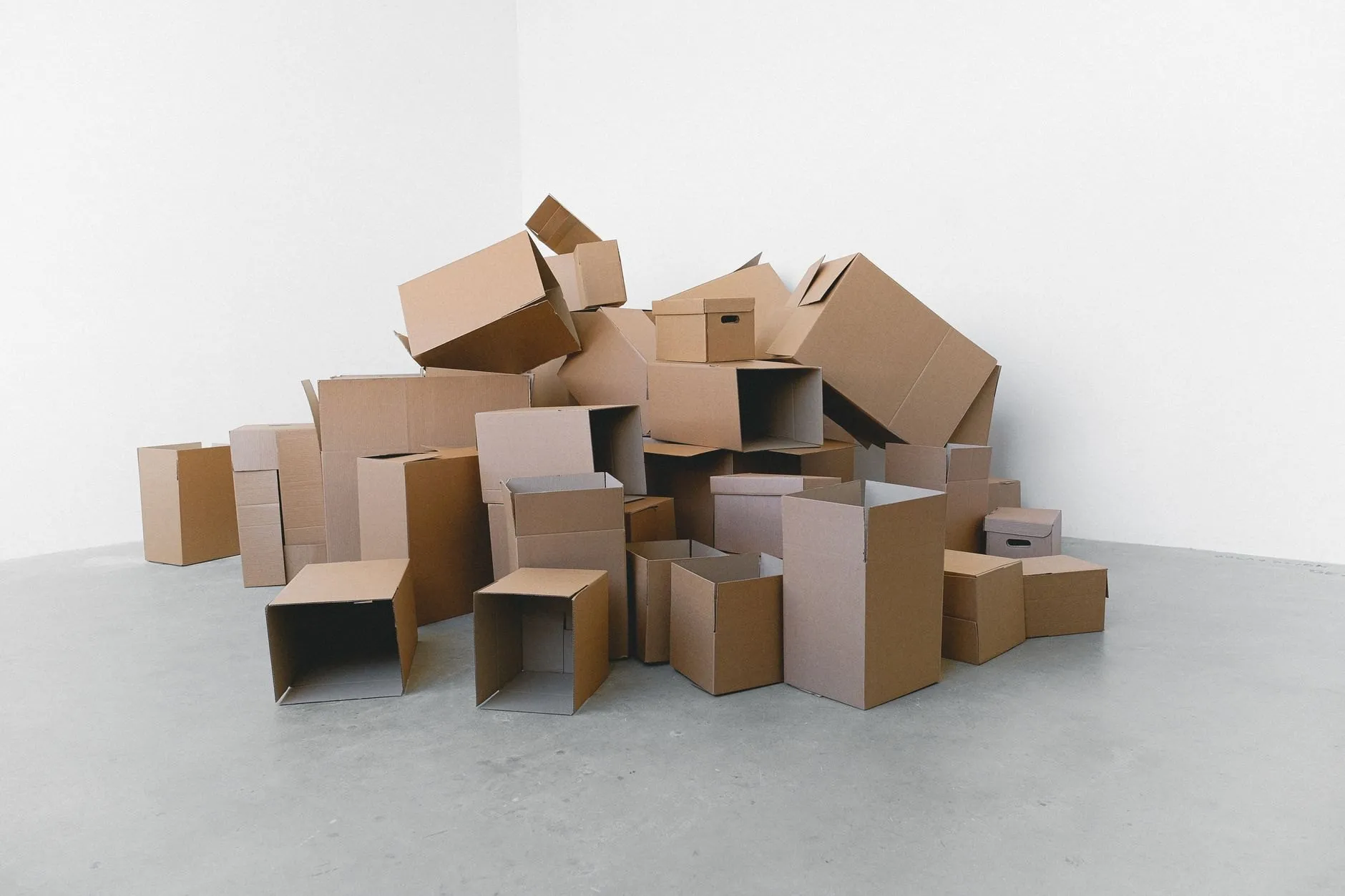 Plain cardboard boxes stacked on a pale concrete floor